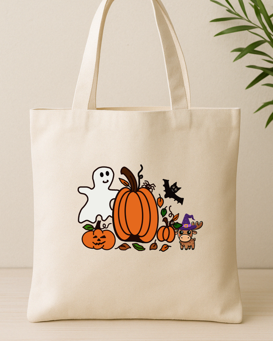 Cute Halloween graphic on a cream tote bag with a ghost, pumpkins, and a moose in a witch hat.